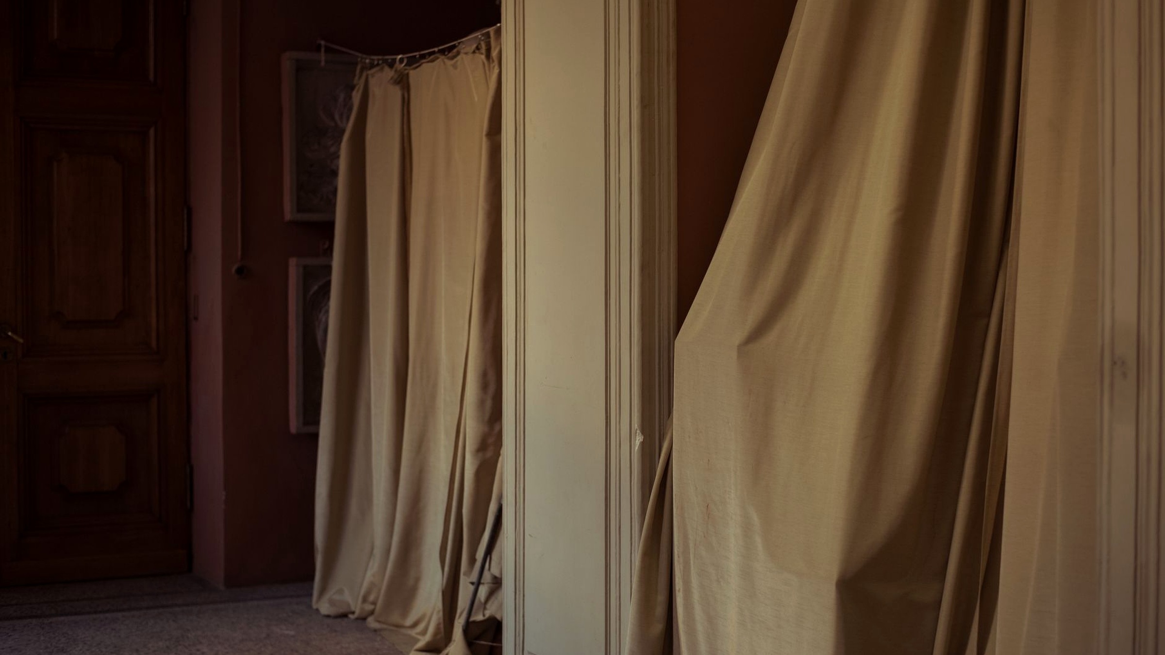 Event room with uplighting, draped backdrop and a styled photo corner before guests arrive