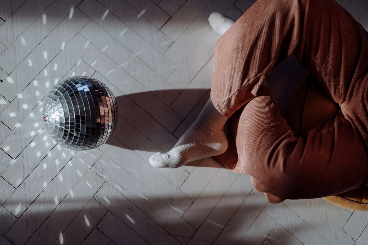 Event floor with coloured wash lighting, a mirror ball and adult guests dancing