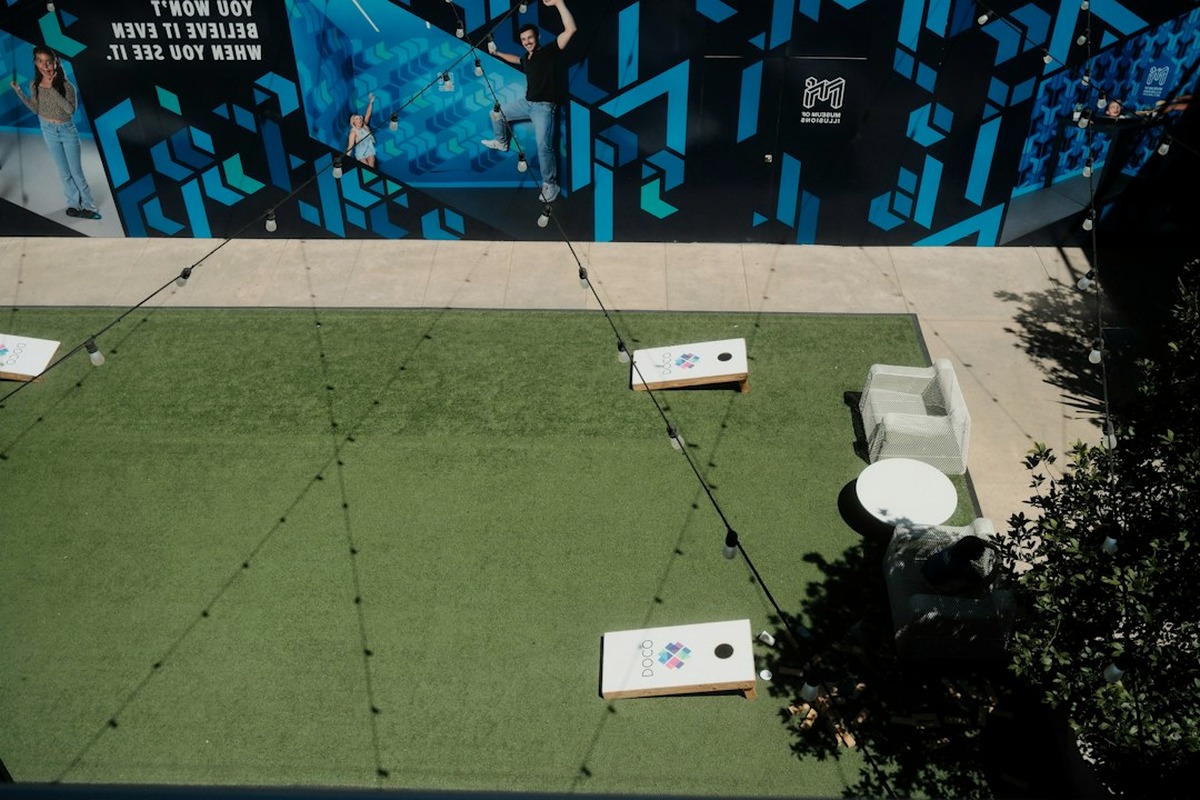 Outdoor event area with station marquees, bunting and adult guests in casual clothes