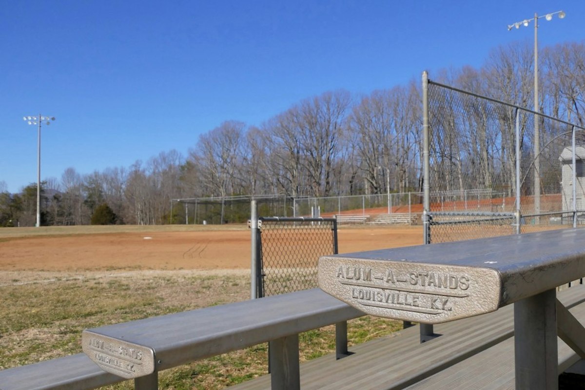 Outdoor station area with marquees, scoreboard and adult guests in team sashes