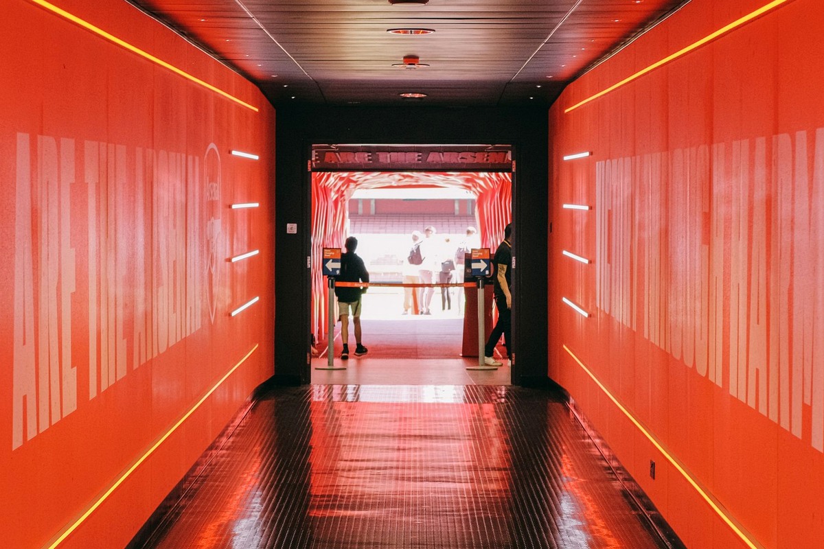 Red carpet with stanchions and a press wall at an event entrance with adult guests arriving