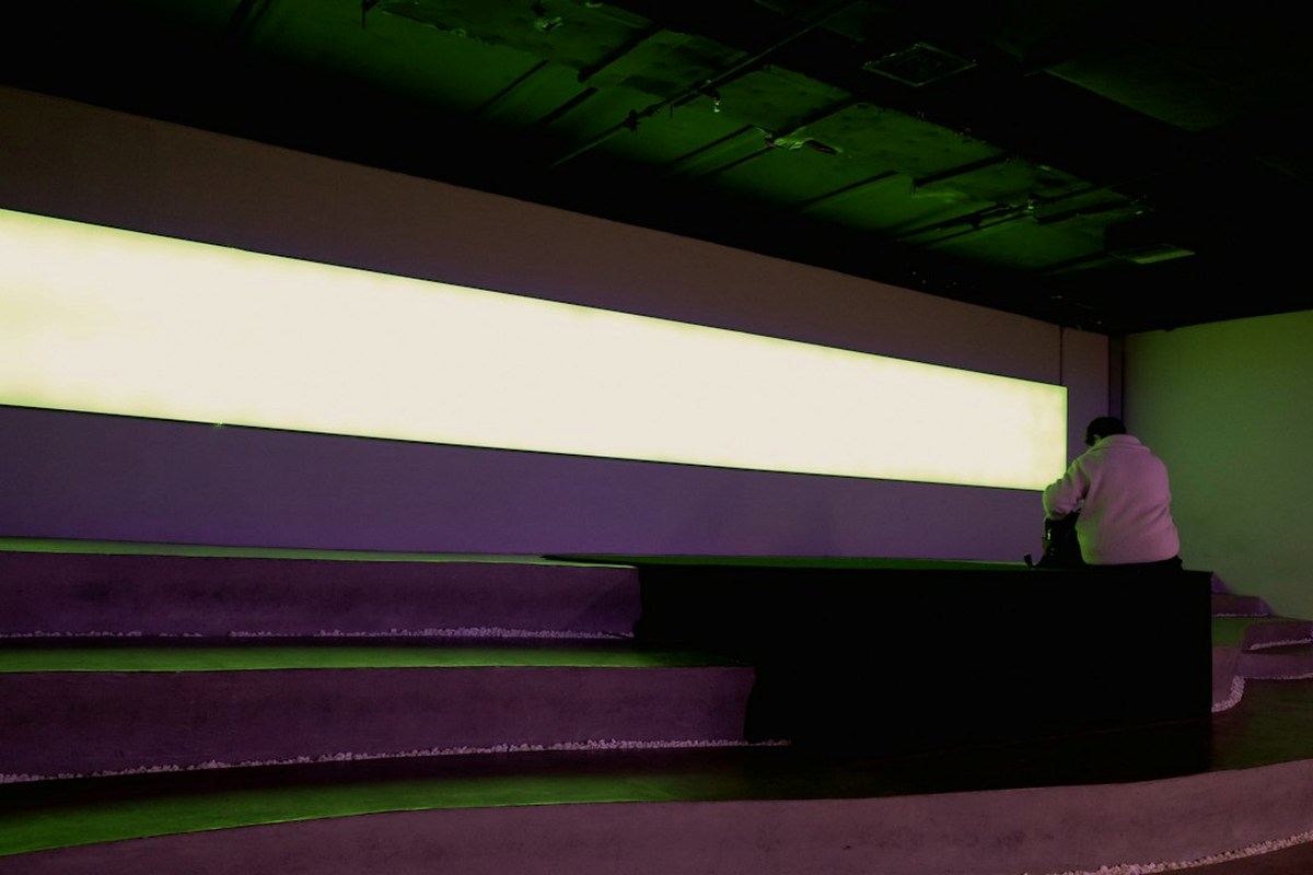 Event room with UV lighting, reactive fabric panels and a writing wall with adult guests