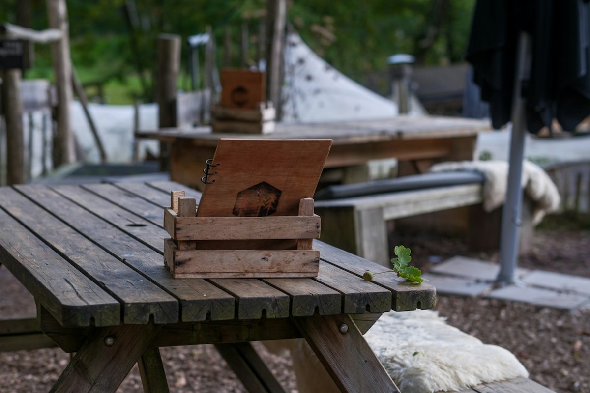 Checkpoint station with signage, a clue box and a host in a garden setting
