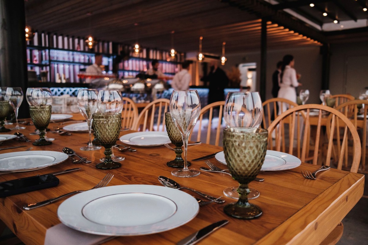 Event floor during a company evening with dressed tables, a photo corner and adult guests